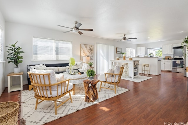 living room featuring ceiling fan and dark wood-type flooring