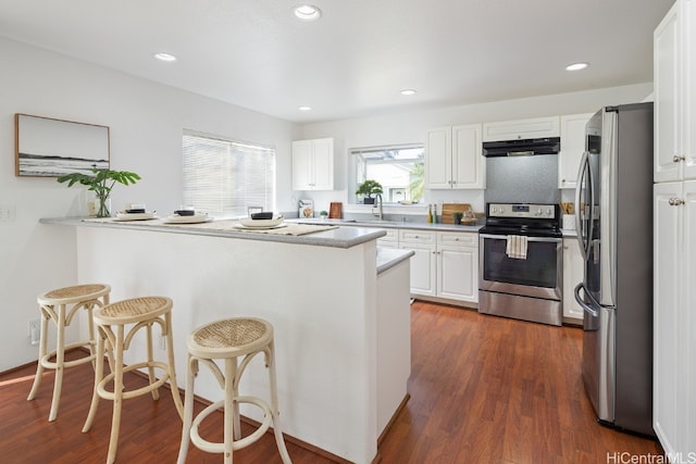 kitchen with a wealth of natural light, kitchen peninsula, and appliances with stainless steel finishes