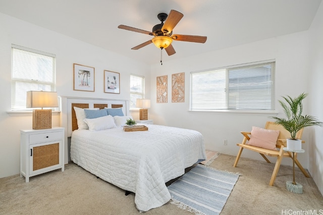 bedroom with light carpet, multiple windows, and ceiling fan