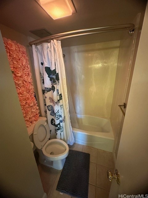 bathroom featuring tile patterned flooring, shower / bath combo, and toilet