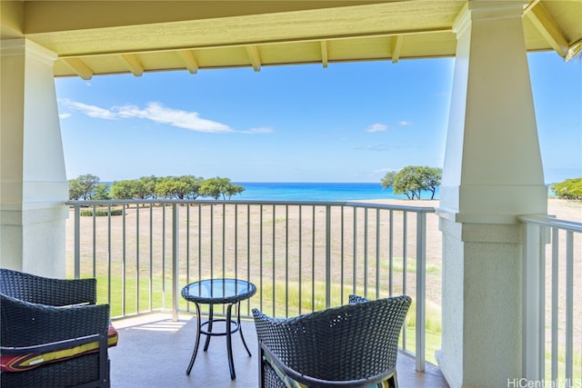 balcony with a water view and a view of the beach