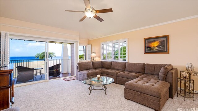 living room with ceiling fan, a water view, ornamental molding, and light carpet