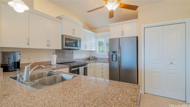 kitchen with white cabinetry, sink, stainless steel appliances, vaulted ceiling, and decorative backsplash