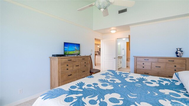 carpeted bedroom with ensuite bath, ceiling fan, crown molding, and a towering ceiling