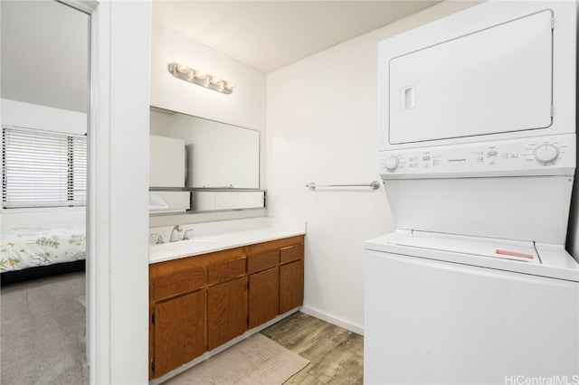 bathroom featuring vanity, wood-type flooring, and stacked washer / drying machine