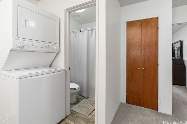 washroom with light carpet and stacked washer and clothes dryer