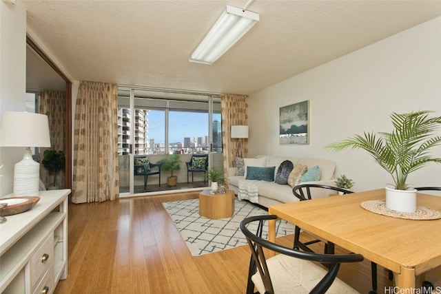 living room featuring floor to ceiling windows, a textured ceiling, and hardwood / wood-style flooring