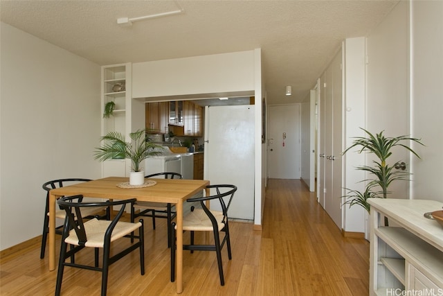 dining room featuring a textured ceiling and light wood-type flooring