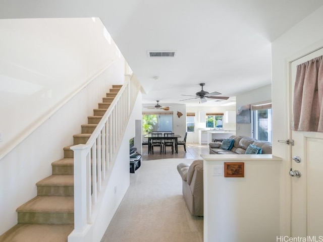 carpeted living room featuring ceiling fan