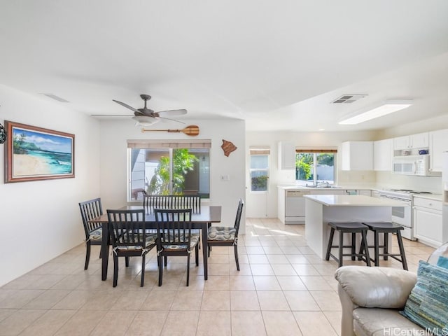 tiled dining space featuring ceiling fan and sink