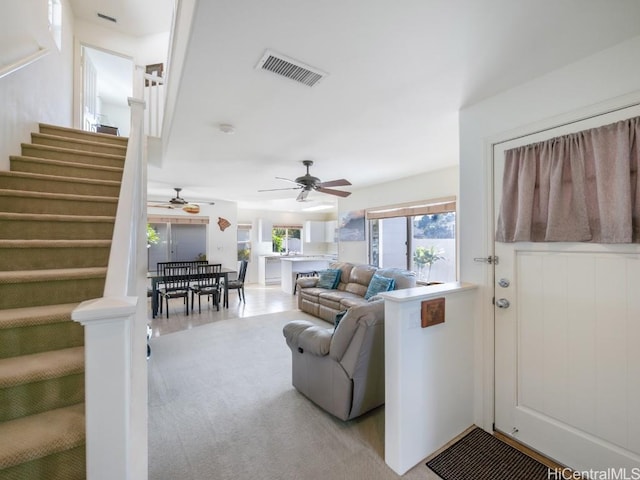 carpeted living room with ceiling fan