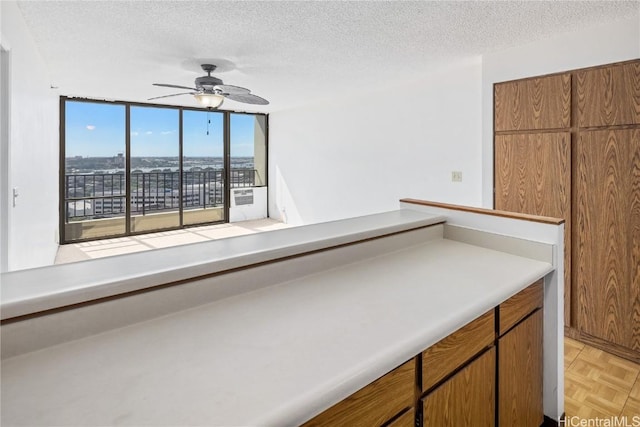 kitchen featuring ceiling fan, a textured ceiling, and light parquet floors