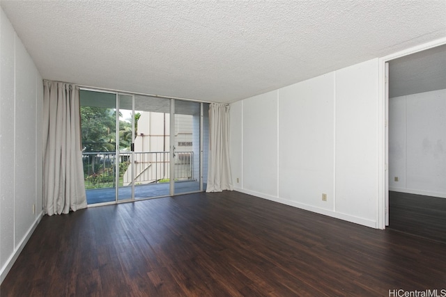 unfurnished room featuring floor to ceiling windows, dark hardwood / wood-style flooring, and a textured ceiling