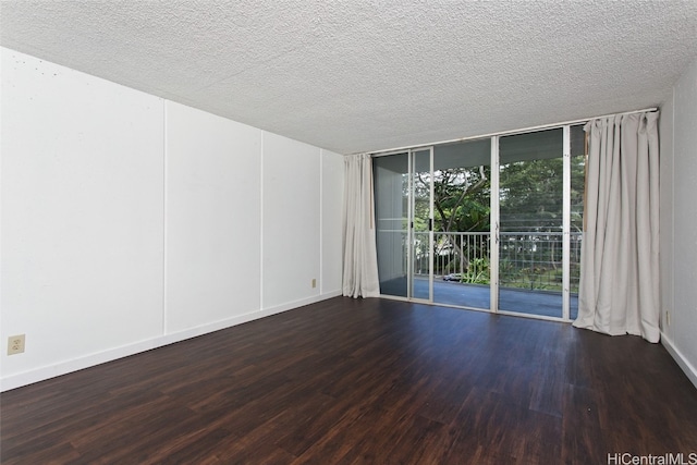 unfurnished room featuring floor to ceiling windows, wood-type flooring, and a textured ceiling