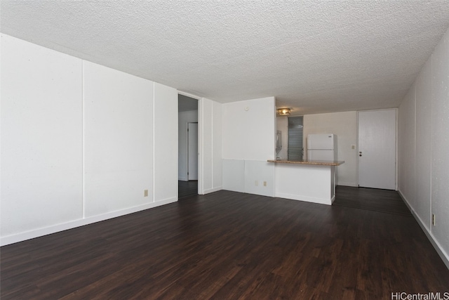 unfurnished living room featuring a textured ceiling and dark wood-type flooring