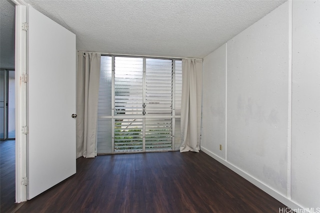 unfurnished room featuring dark hardwood / wood-style floors and a textured ceiling