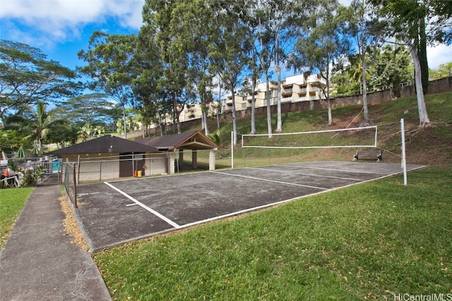 view of property's community with a lawn and tennis court