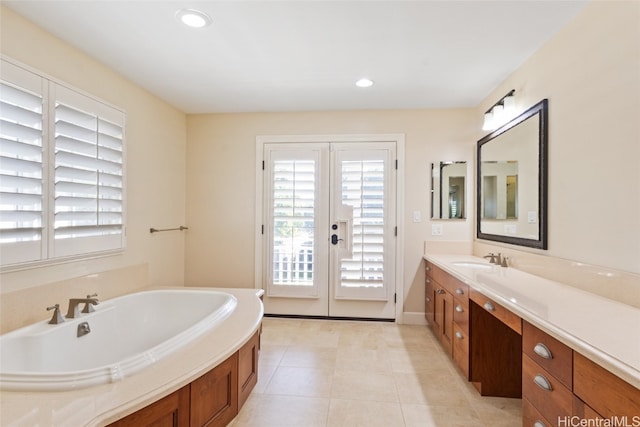 bathroom with tile patterned flooring, vanity, a bathing tub, and french doors