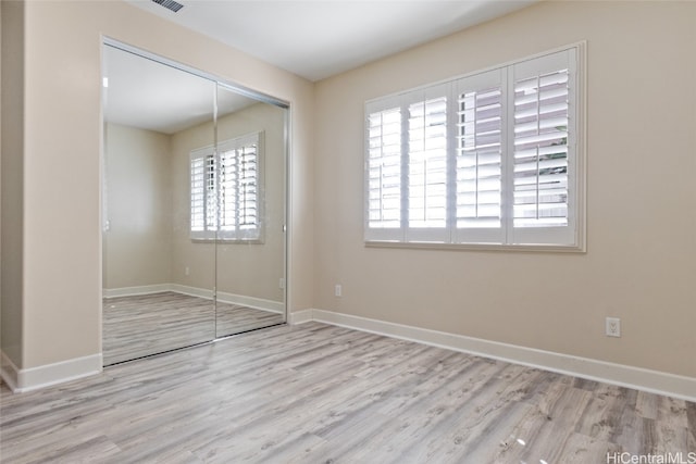 unfurnished bedroom featuring a closet and light hardwood / wood-style flooring