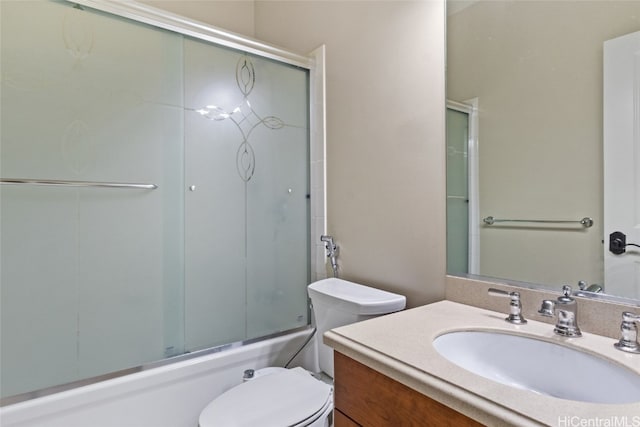 full bathroom featuring shower / bath combination with glass door, vanity, and toilet