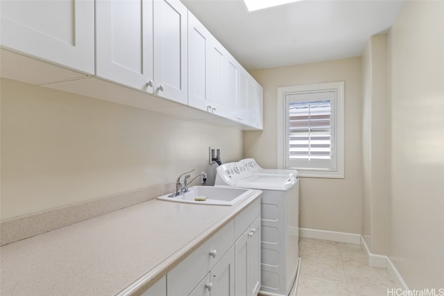 laundry area with cabinets, light tile patterned floors, sink, and washing machine and dryer