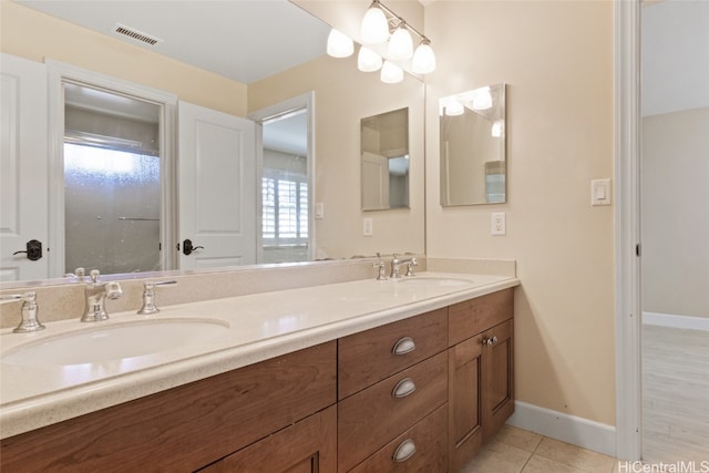 bathroom with tile patterned flooring, vanity, and a healthy amount of sunlight