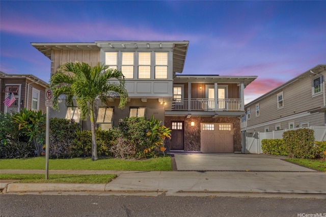91-1044 Kai Oio St, Ewa Beach, HI 96706 - view of front of property featuring a balcony, an attached garage, concrete driveway, stone siding, and board and batten siding