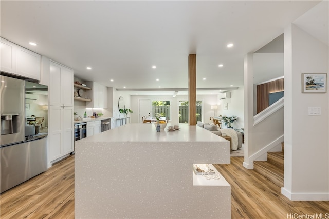 kitchen with a kitchen island, light wood-type flooring, white cabinetry, and stainless steel refrigerator with ice dispenser