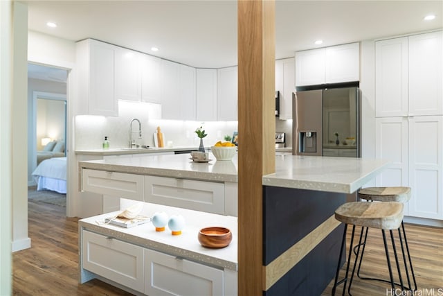 kitchen with white cabinets, stainless steel fridge, and dark wood-type flooring