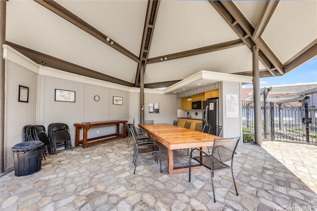 dining space with lofted ceiling with beams