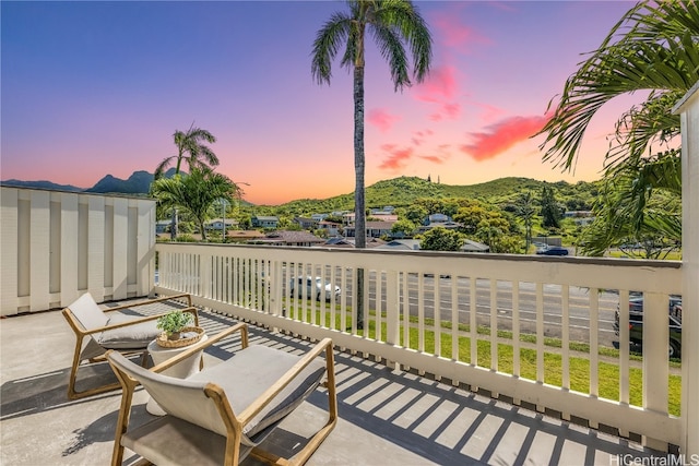 patio terrace at dusk featuring a mountain view and a balcony