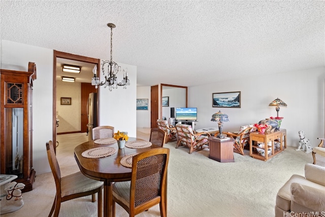 carpeted dining room featuring a chandelier and a textured ceiling