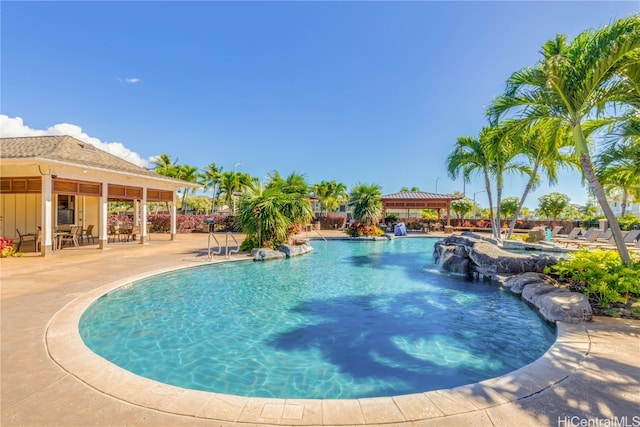 view of swimming pool featuring pool water feature and a patio area