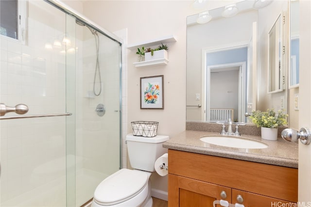 bathroom featuring an enclosed shower, vanity, and toilet