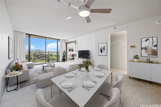 carpeted dining space featuring floor to ceiling windows, ceiling fan, and a textured ceiling