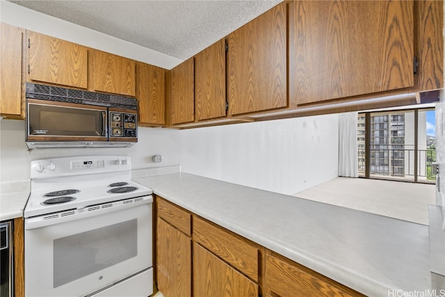 kitchen featuring electric range and a textured ceiling