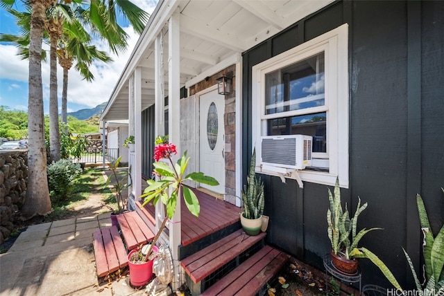 property entrance featuring a porch, a mountain view, and cooling unit