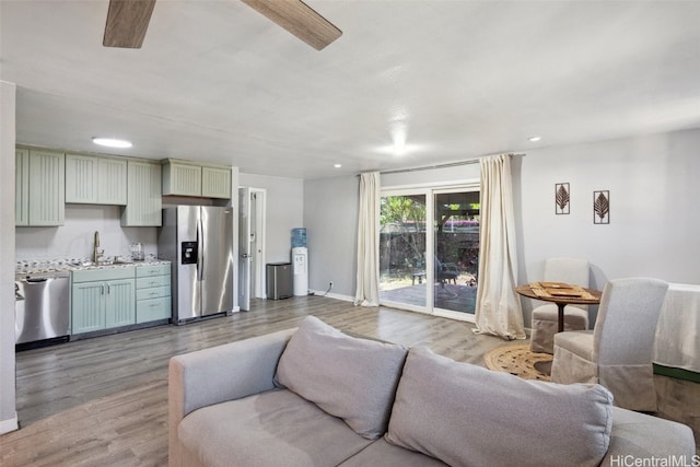 living room featuring ceiling fan, hardwood / wood-style floors, and sink