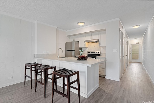 1642 Kewalo St Unit 208, Honolulu, HI 96822 - kitchen featuring under cabinet range hood, a sink, freestanding refrigerator, light countertops, and light wood finished floors