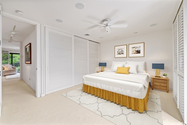 carpeted bedroom with ceiling fan and a closet