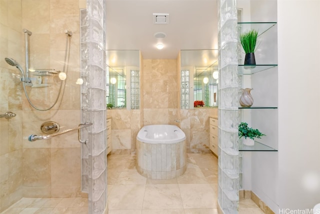 bathroom with a shower with door, tile walls, and tile patterned flooring