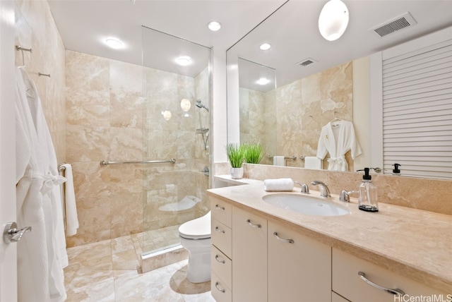 bathroom featuring tiled shower, vanity, tile walls, and toilet