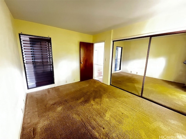 unfurnished bedroom featuring carpet flooring and a closet