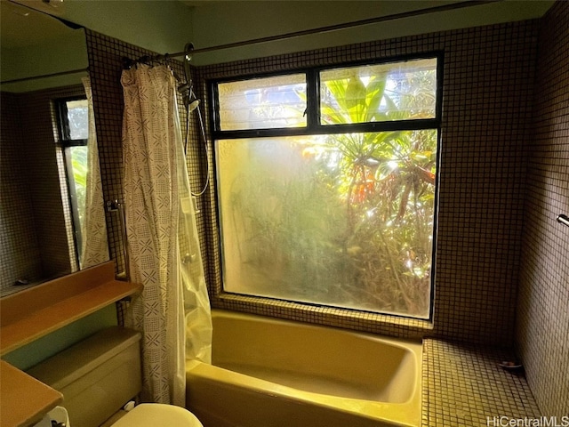 interior details featuring toilet and shower / bath combo with shower curtain