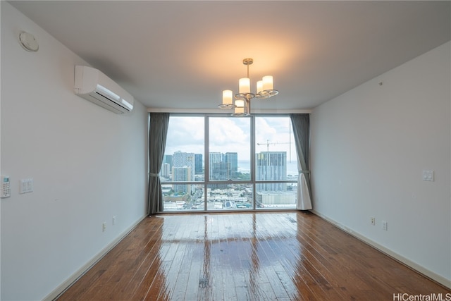 empty room featuring a wall mounted air conditioner, expansive windows, hardwood / wood-style flooring, and a chandelier