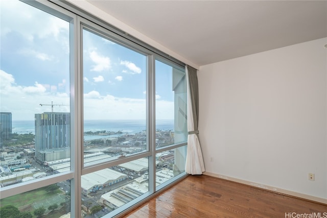 unfurnished room with a water view and hardwood / wood-style flooring