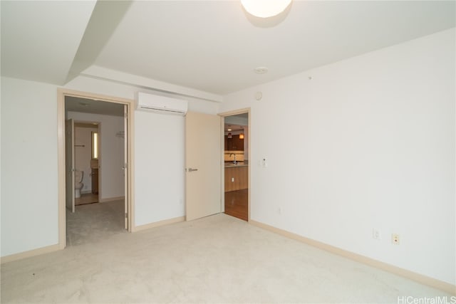 unfurnished bedroom featuring an AC wall unit, sink, and light colored carpet