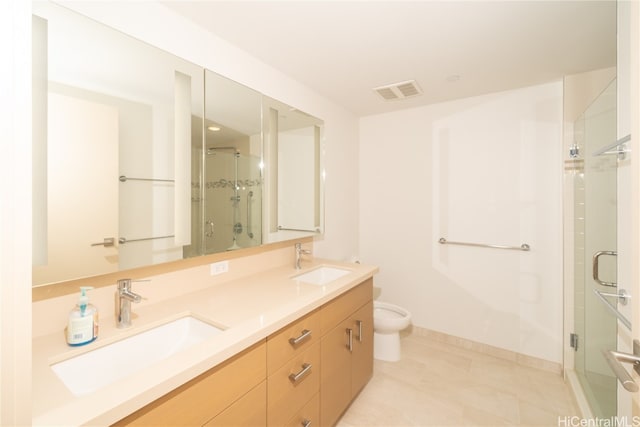 bathroom with tile patterned flooring, vanity, toilet, and a shower with door