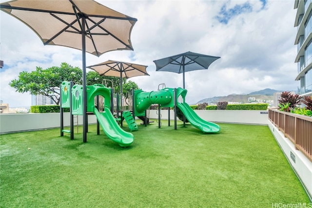 view of play area with a lawn and a mountain view