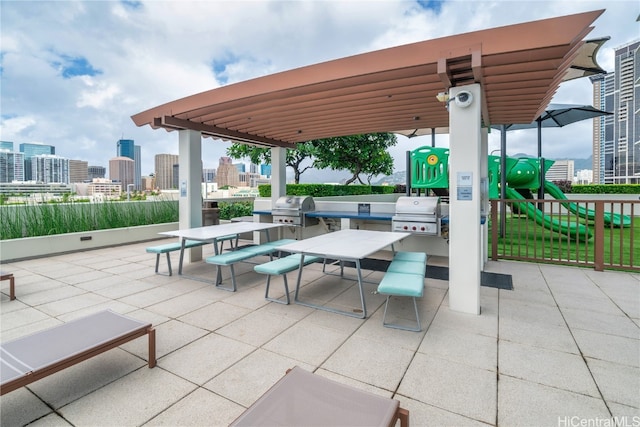 view of patio featuring a playground and a grill